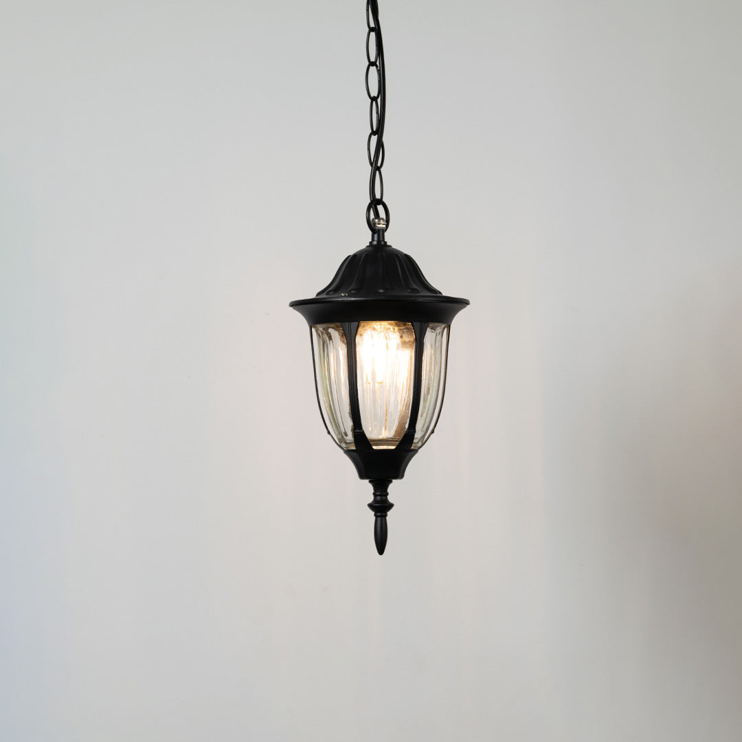 Contemporary black metal hanging lantern light with warm glow for elegant balcony and porch decor.