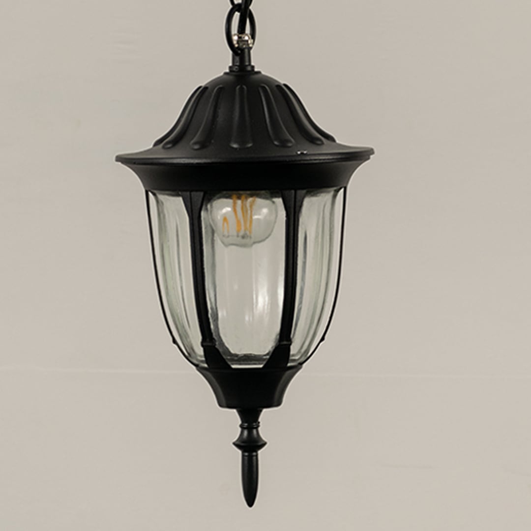 Detailed closeup of outdoor hanging lantern light showing top metal frame and curved edges.