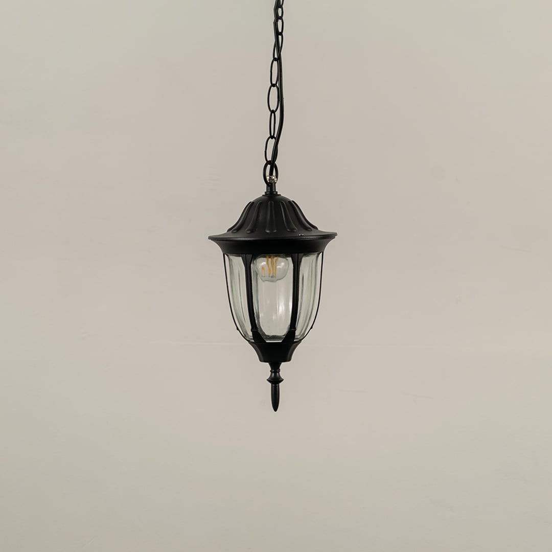Black outdoor hanging lantern light turned off on white background highlighting design and material finish.