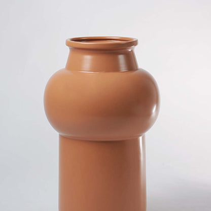 Closeup of sculptural brown ceramic vase displaying fine texture and smooth rounded detailing reflecting expert ceramic craftsmanship.