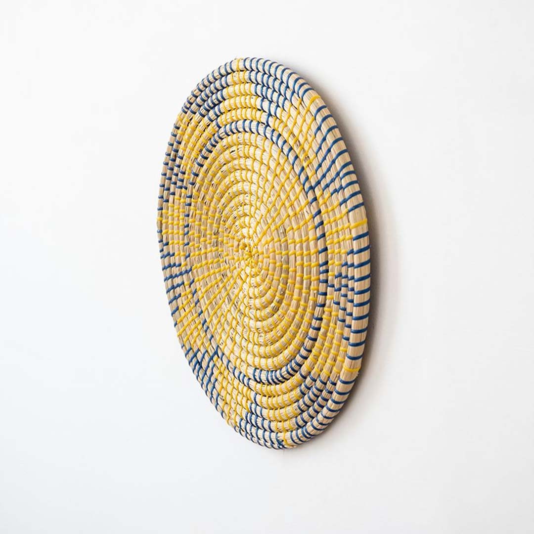 Handwoven wicker wall plate side view showing yellow navy and beige woven texture for stylish boho wall decor.