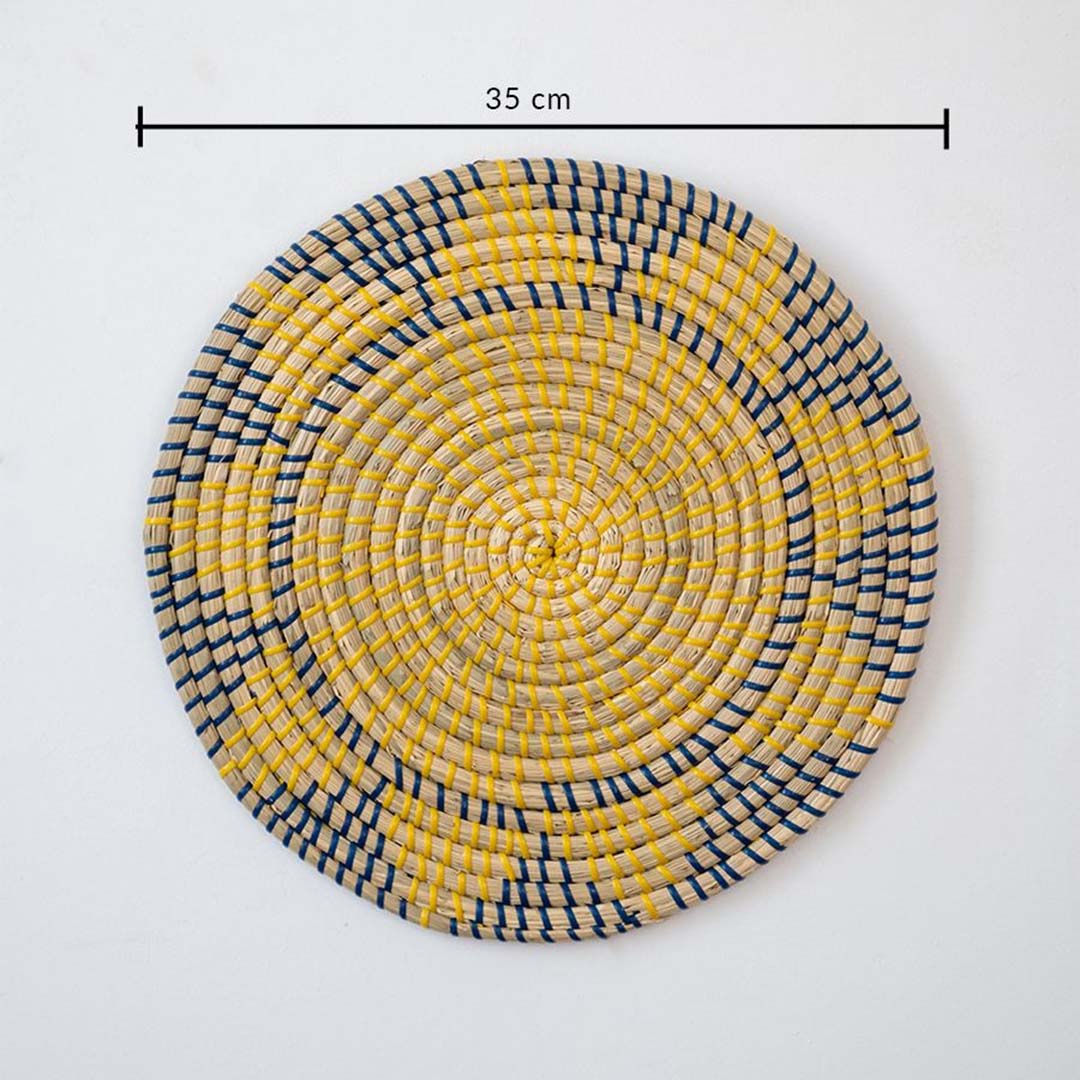 Round wicker wall plate decor measuring 35 cm handwoven in natural beige yellow and navy geometric woven design.