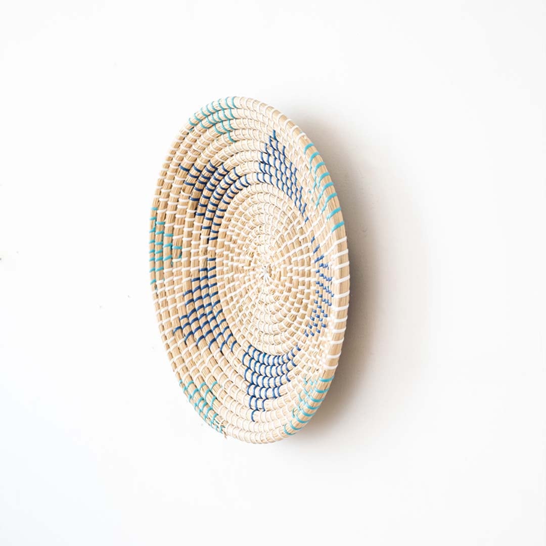 Side view of handwoven wall basket decor made of rustic natural fiber with boho pattern design for wall decoration.