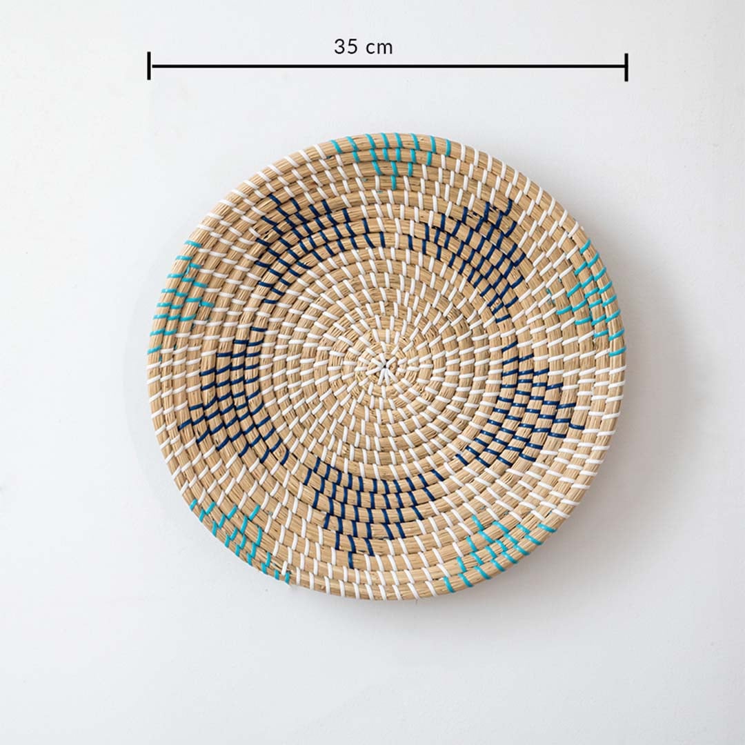 Handwoven wall basket decor in natural beige with blue and black pattern shown with 35cm diameter for wall use.