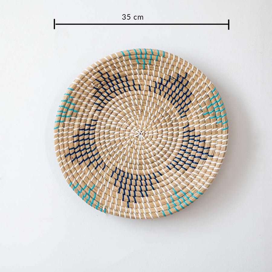 Handwoven wall basket decor in natural beige with blue and black pattern shown with 35cm diameter for wall use.