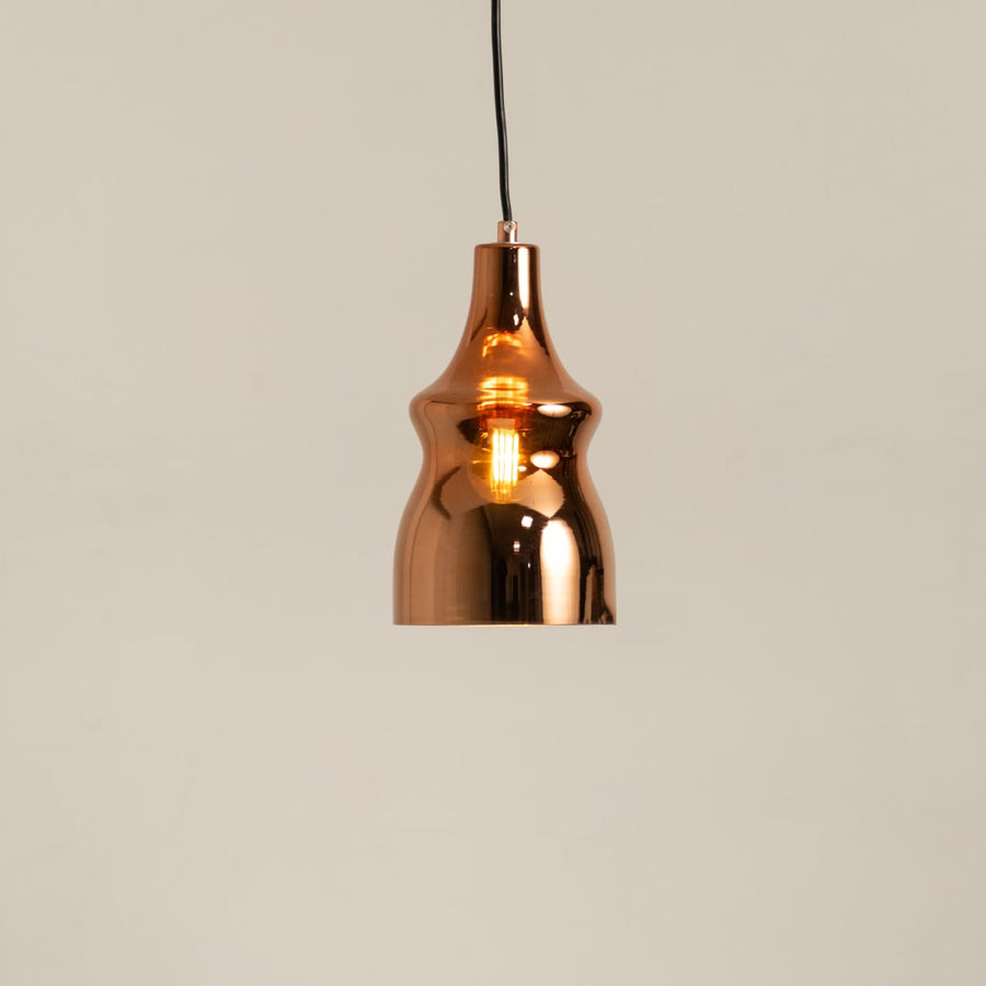 Copper metal pendant light glowing softly on a clean white background showcasing its modern reflective curved design.