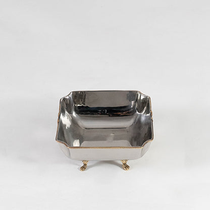 Decorative silver metal square bowl with ornate gold design and foot base shown front-facing on white background.