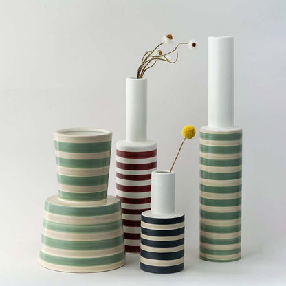A stylish striped vase displayed with complementary decor pieces creating a coordinated modern look perfect for enhancing interior styling.