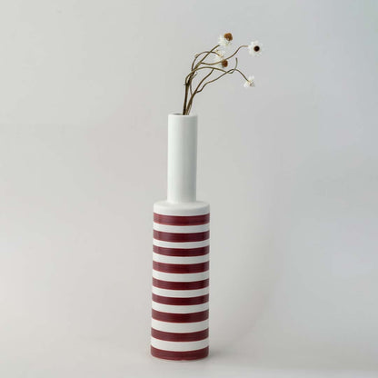 A tall modern striped vase captured in a soft lifestyle setup showcasing its slim neck bold bands and elegant height for contemporary home styling.