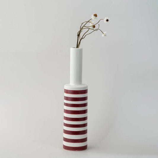 A tall modern striped vase captured in a soft lifestyle setup showcasing its slim neck bold bands and elegant height for contemporary home styling.