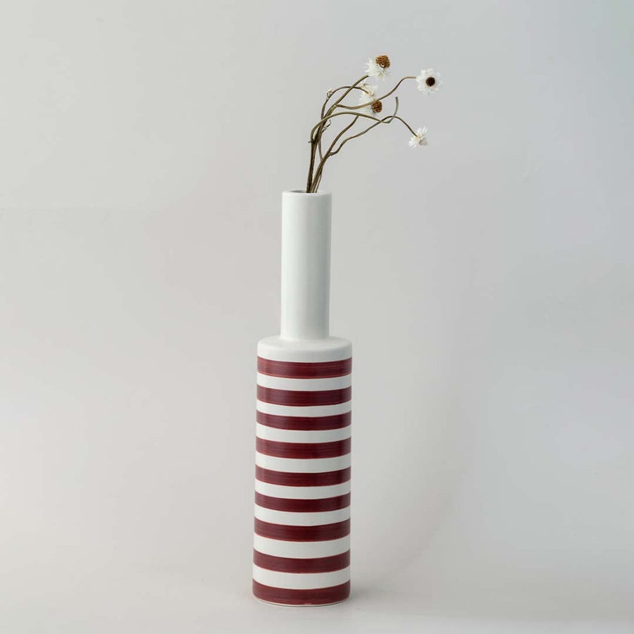 A tall modern striped vase captured in a soft lifestyle setup showcasing its slim neck bold bands and elegant height for contemporary home styling.