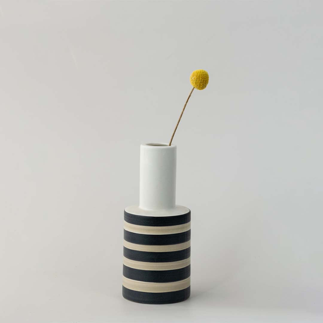 White ceramic decorative vase with black stripes and gold detail for tabletop styling and modern home decor.
