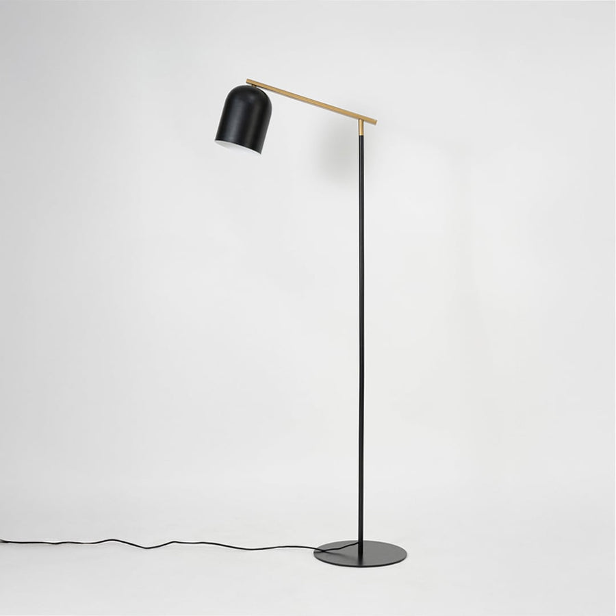 Detailed view of matte black dome lampshade on gold rod arm offering directional lighting for modern spaces
