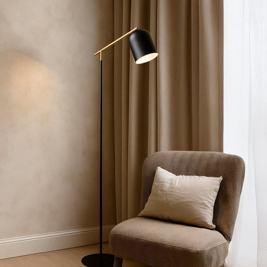 Angled floor lamp with gold arm and black shade shown on white background for contemporary lighting product display