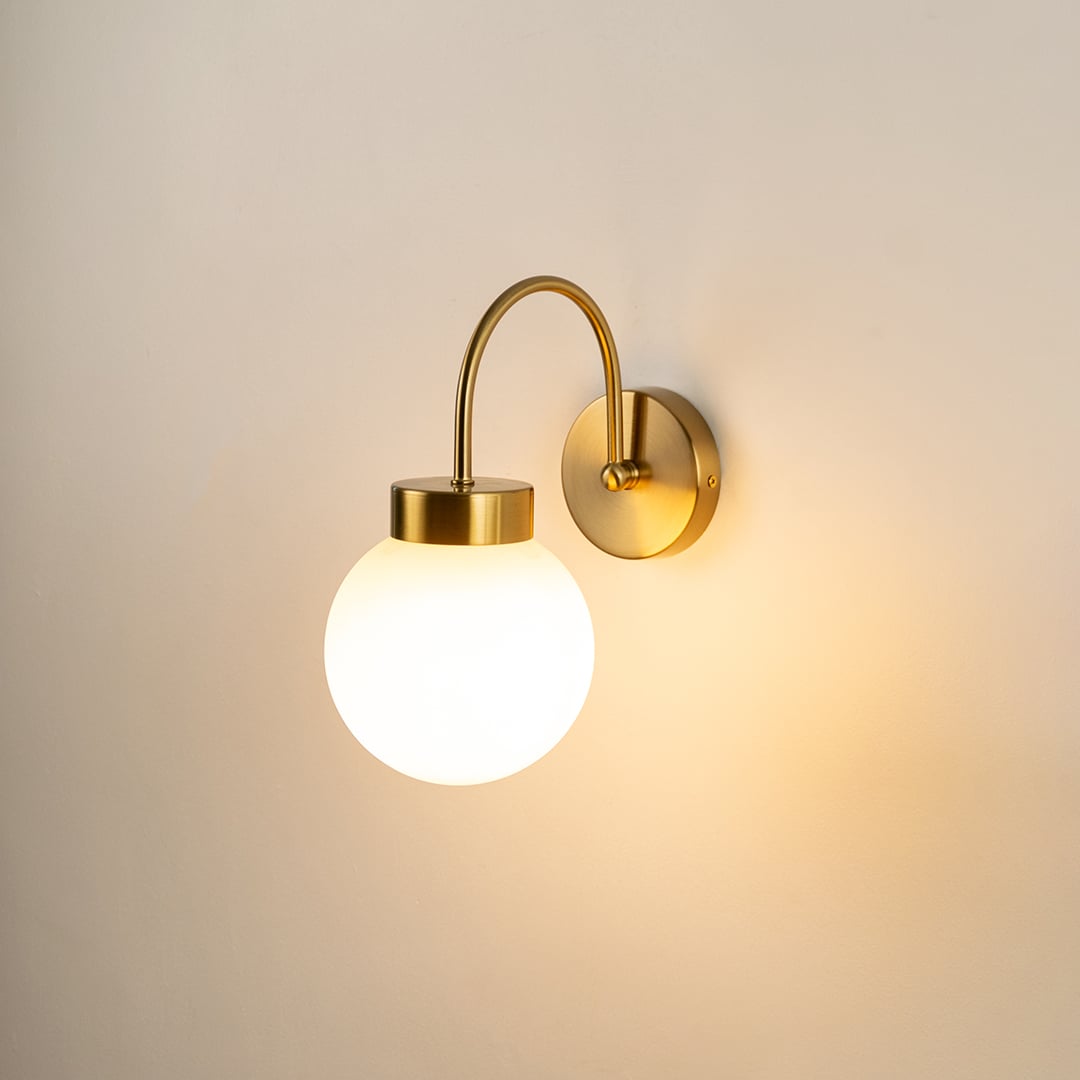 Modern gold metal wall light with white glass globe for elegant hallway and luxury decor styling spaces.