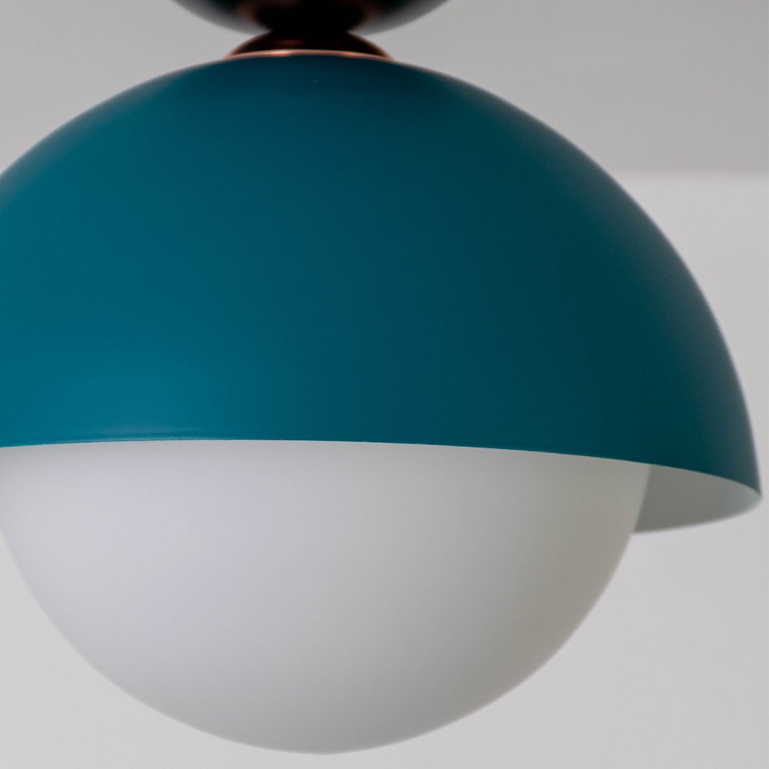 Closeup view of the teal dome ceiling light highlighting its smooth finish and soft white globe design.
