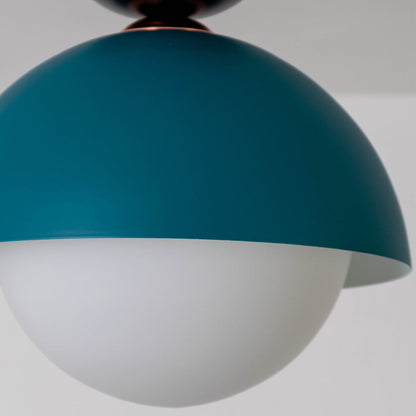 Closeup view of the teal dome ceiling light highlighting its smooth finish and soft white globe design.
