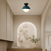 Modern ceiling light in a simple room view with a teal dome shade and white globe creating a soft warm glow.