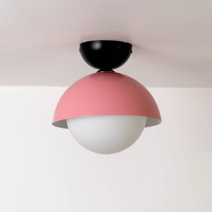 Ceiling light displayed off on a white background featuring a pink dome shade paired with a round white globe.