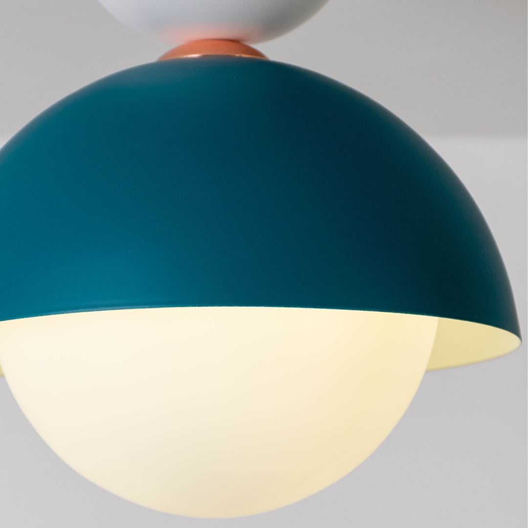 Closeup view of the teal dome ceiling light highlighting its smooth finish and round white globe design.