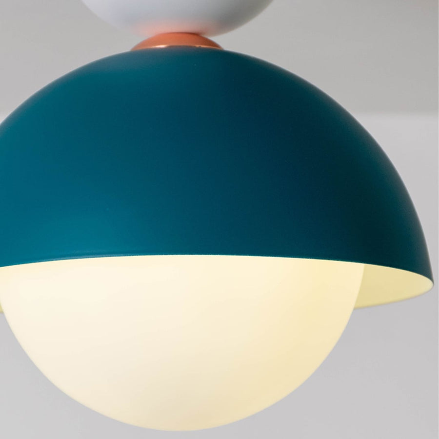 Closeup view of the teal dome ceiling light highlighting its smooth finish and round white globe design.