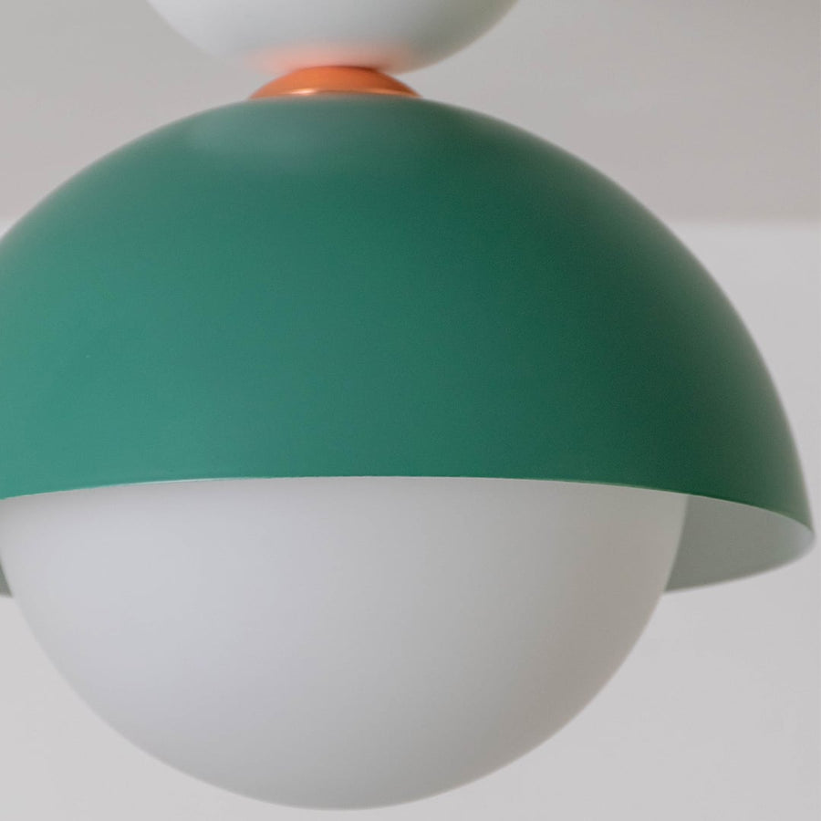 Closeup view of the green dome ceiling light highlighting its smooth finish and round white globe design.