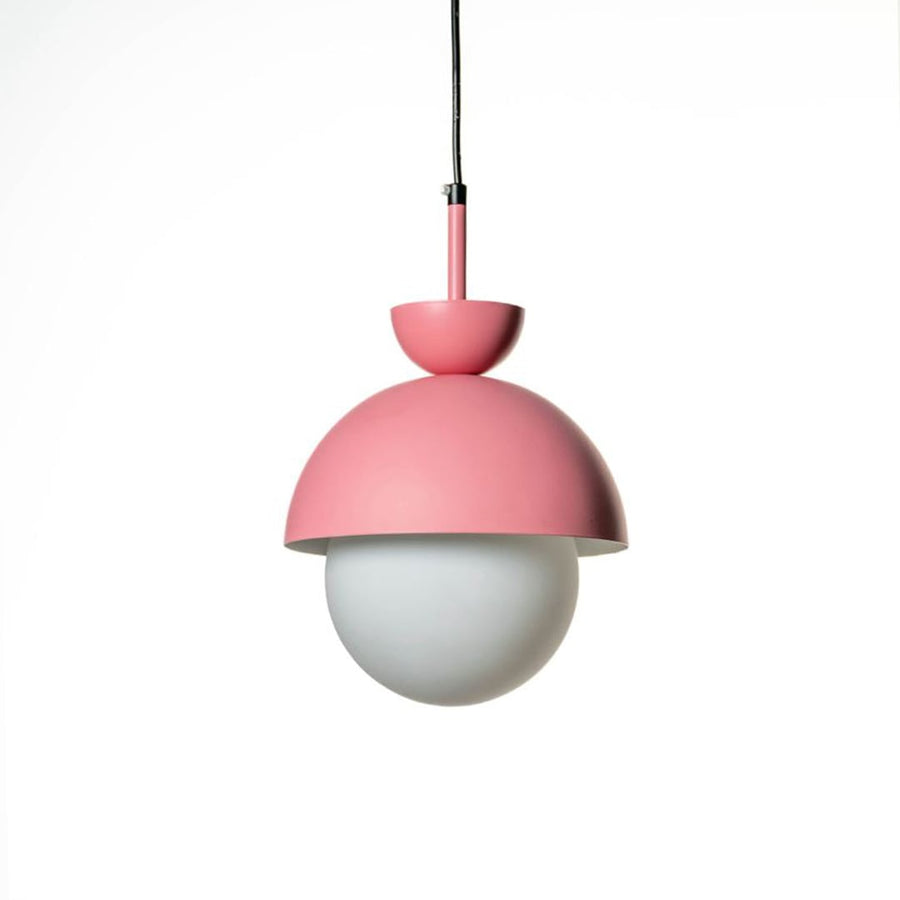 Pendant light in matte pink metal with frosted glass globe shade shown turned off highlighting minimalist modern home design.