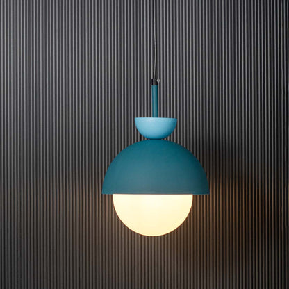 Blue metal pendant light with frosted glass globe illuminated for stylish modern interiors.