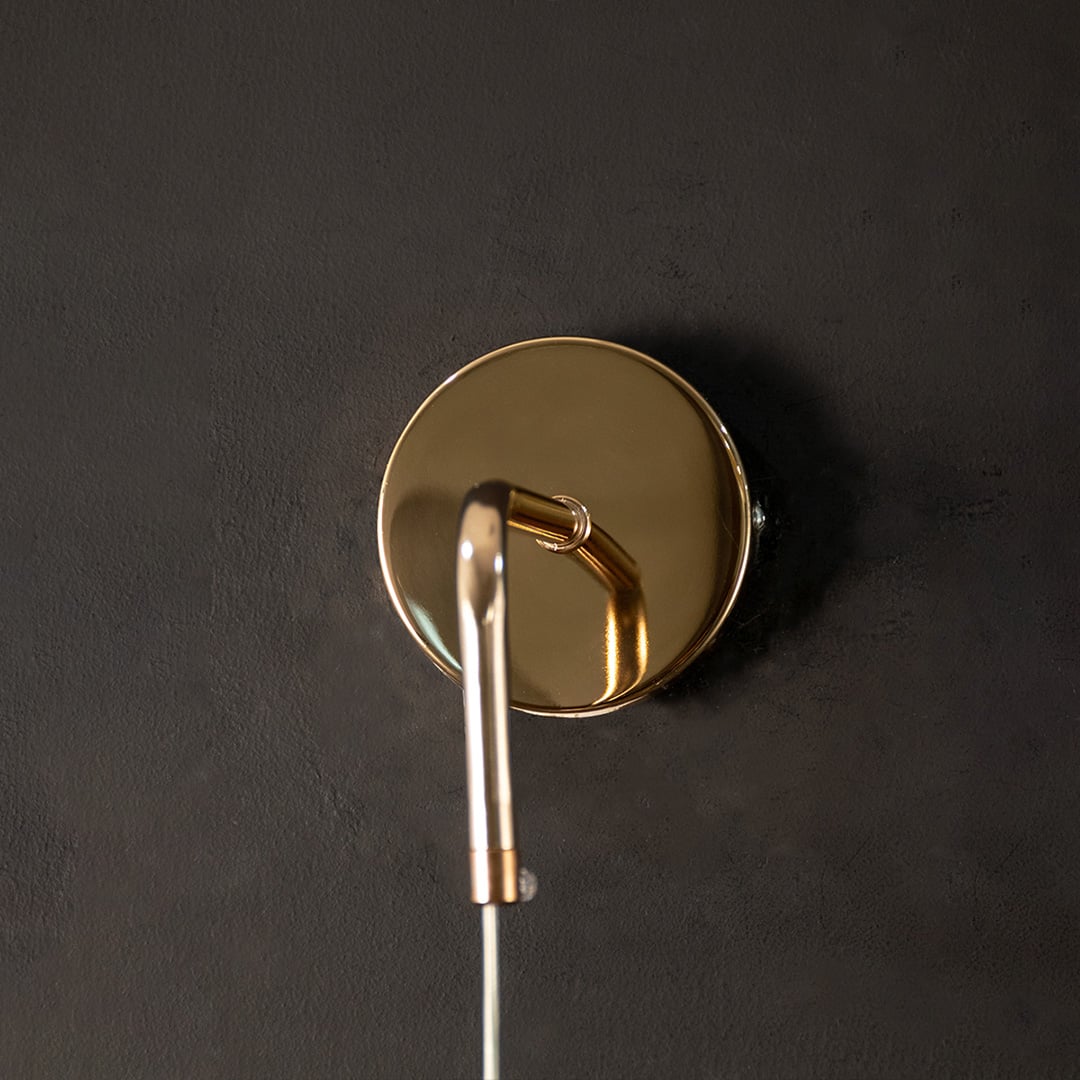 Closeup of gold metal wall mount and holder showing smooth finish premium metal material and sturdy indoor wall lighting construction detail.