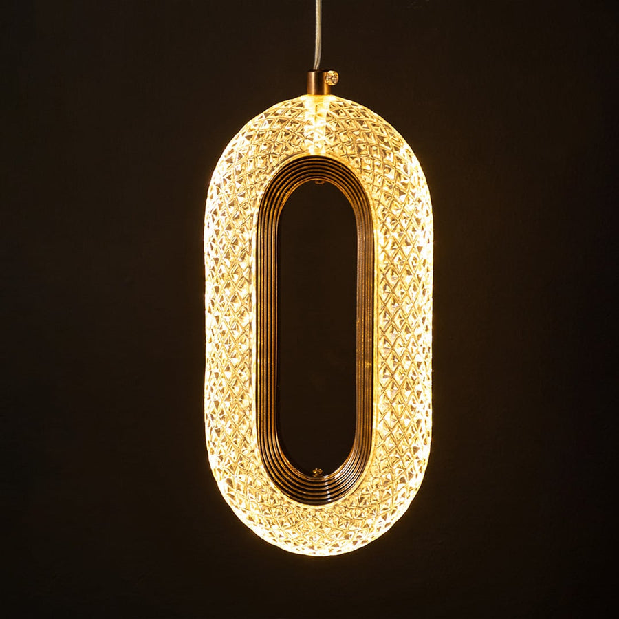 Closeup of oval pendant light with golden frame showcasing fine craftsmanship.