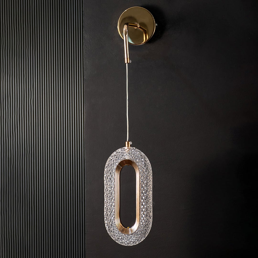 Decorative oval pendant lamp with crystal and gold design displayed unlit on black background.