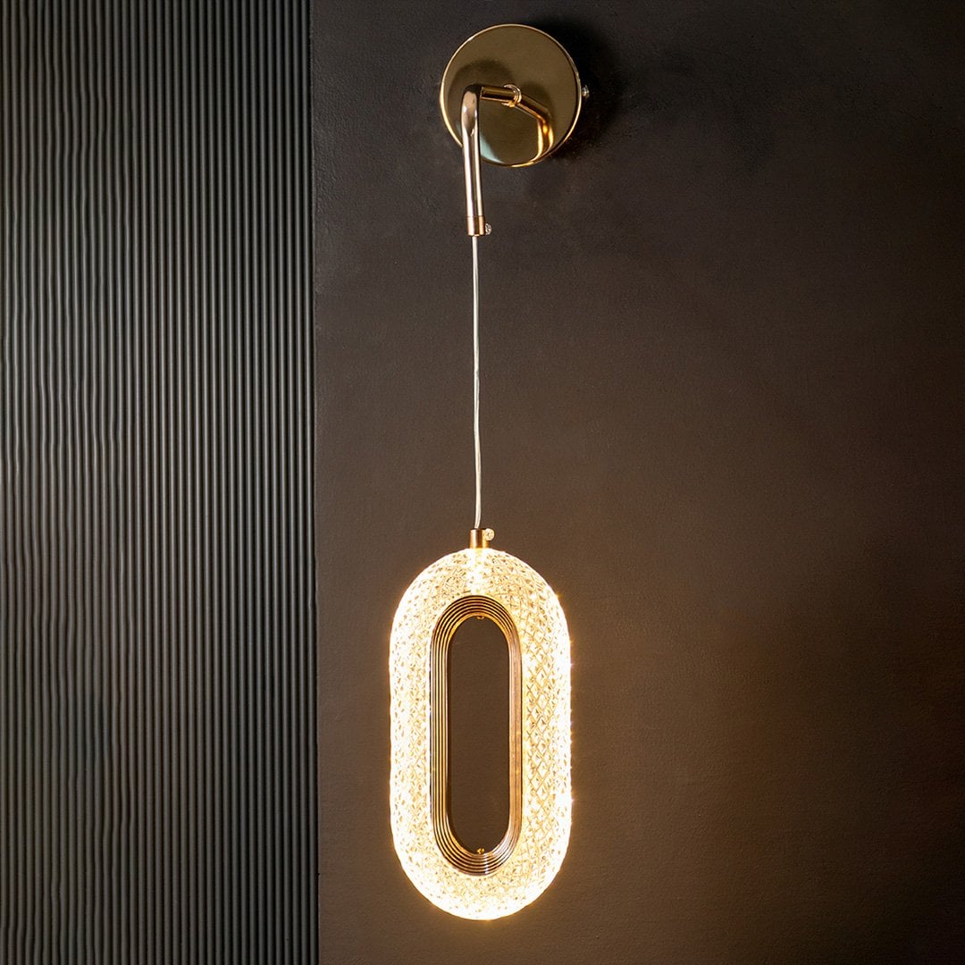 Stylish oval crystal pendant lamp with golden frame glowing against black background for interiors.