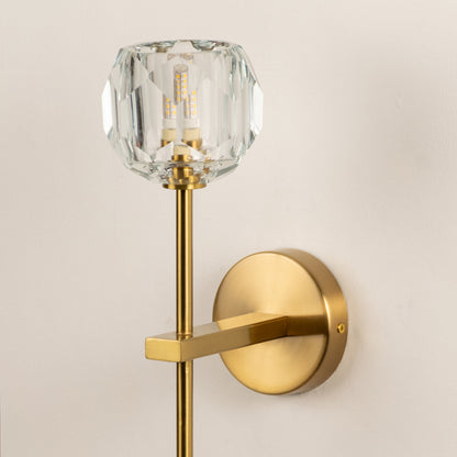 Modern brass wall light with crystal glass shade for elegant bedroom and hallway interior decor.