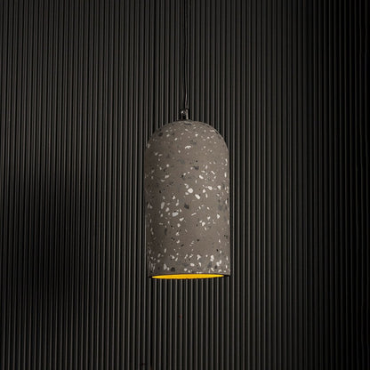Warm glowing terrazzo pendant light highlighting its grey textured surface against a dark background for a modern industrial look.