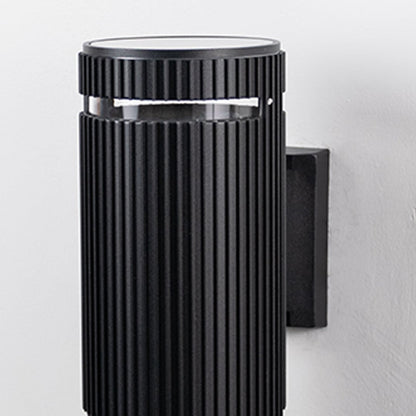 Closeup of black ribbed wall light showcasing detailed vertical grooves and refined matte finish.