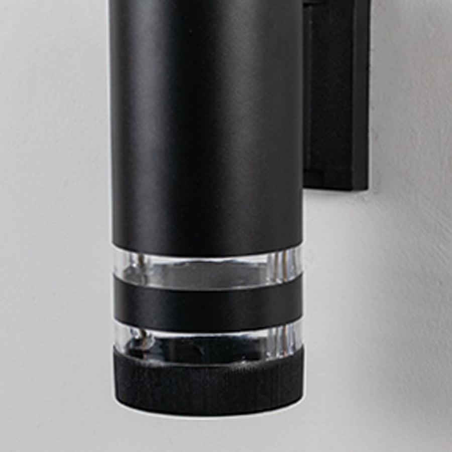Closeup view of black cylindrical wall light showcasing its matte finish and polished acrylic detailing.