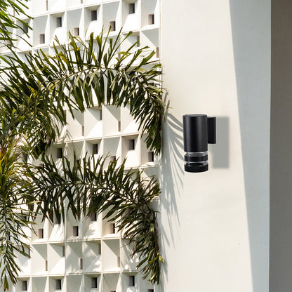 Stylish black cylindrical wall light enhancing modern home exteriors with warm ambient glow and sleek elegance.