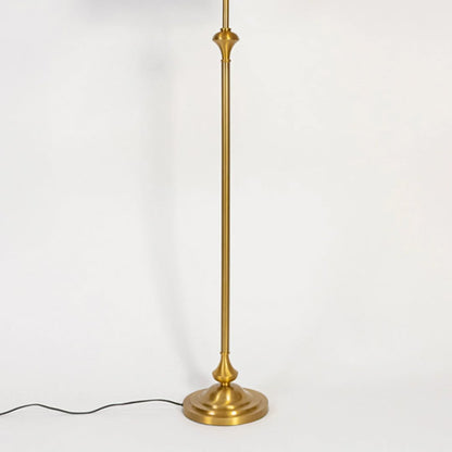 Modern floor lamp with slim gold metal stem and round base placed on white background for elegant living room lighting.