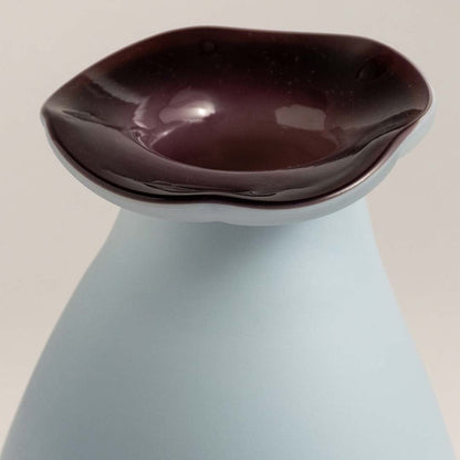 Closeup of ceramic vase showing smooth glossy finish and elegant curved design for stylish interiors.
