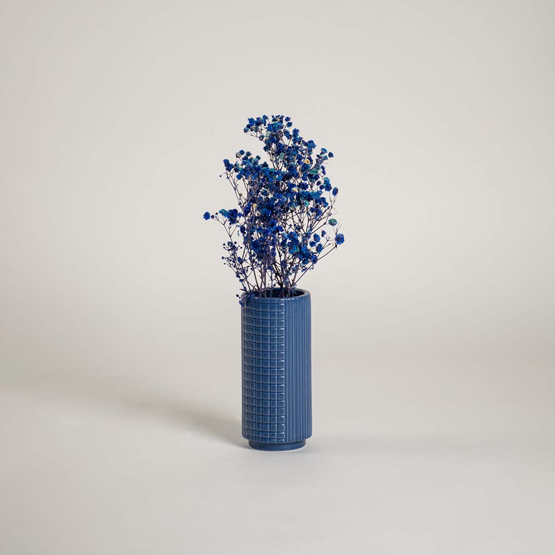 Tall blue ceramic textured vase placed in a modern interior setting perfect for living rooms hallways and stylish home accents.