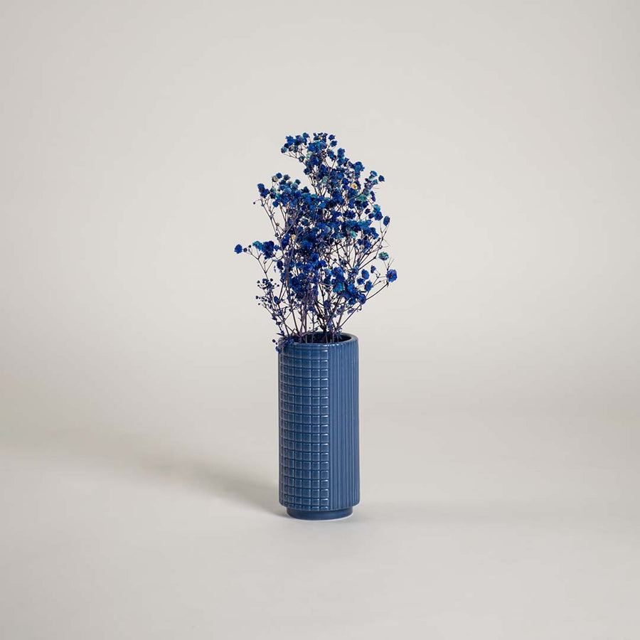 Tall blue ceramic textured vase placed in a modern interior setting perfect for living rooms hallways and stylish home accents.
