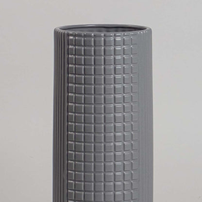 Contemporary grey ceramic vase with grid pattern and clean cylindrical form photographed in soft neutral lighting.