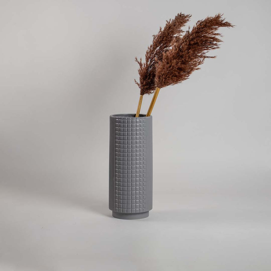 Modern grey ceramic vase with geometric square detailing softly illuminated against a white backdrop for a refined minimal look.