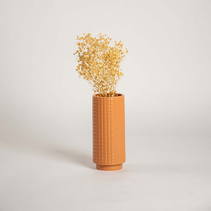 Tall terracotta ceramic textured vase styled in a warm interior space perfect for living rooms hallways and cozy decor accents.