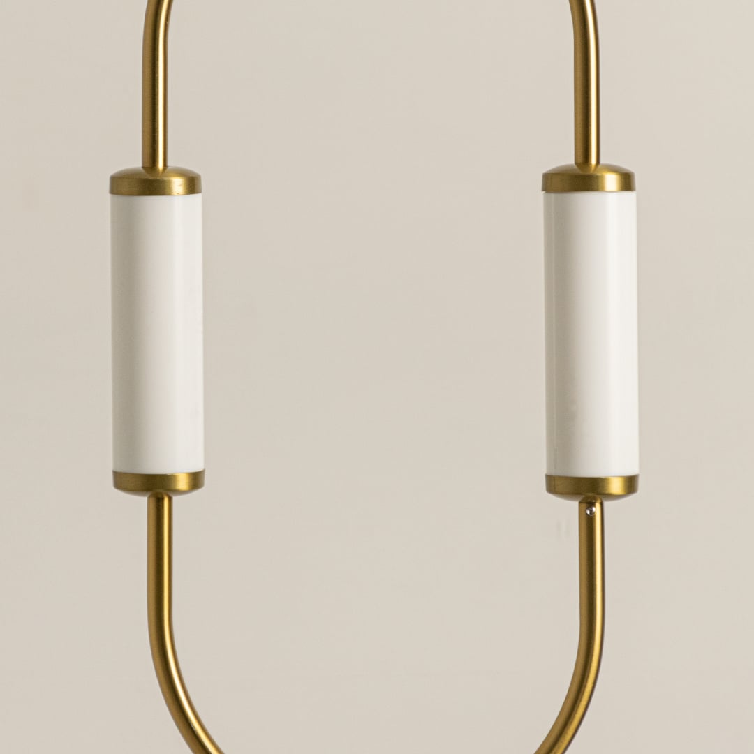 Close up view of brass gold pendant light fixture showing white glass shades and metal frame craftsmanship detail work.