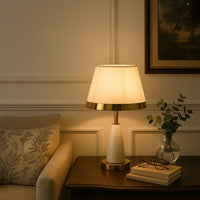 White and gold table lamp with fabric shade styled on wooden side table creating warm cozy living room ambiance table lamp.