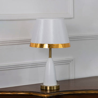 White and gold table lamp with fabric shade turned off on white background elegant bedside and living room table lamp.