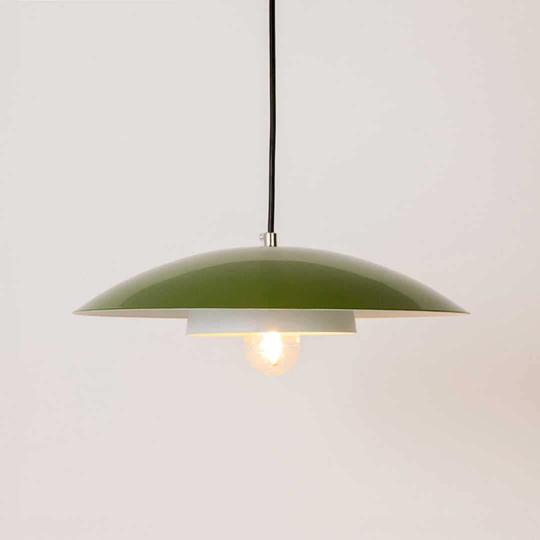 Green metal pendant light glowing softly on white background for stylish kitchen dining and modern living room home decor.