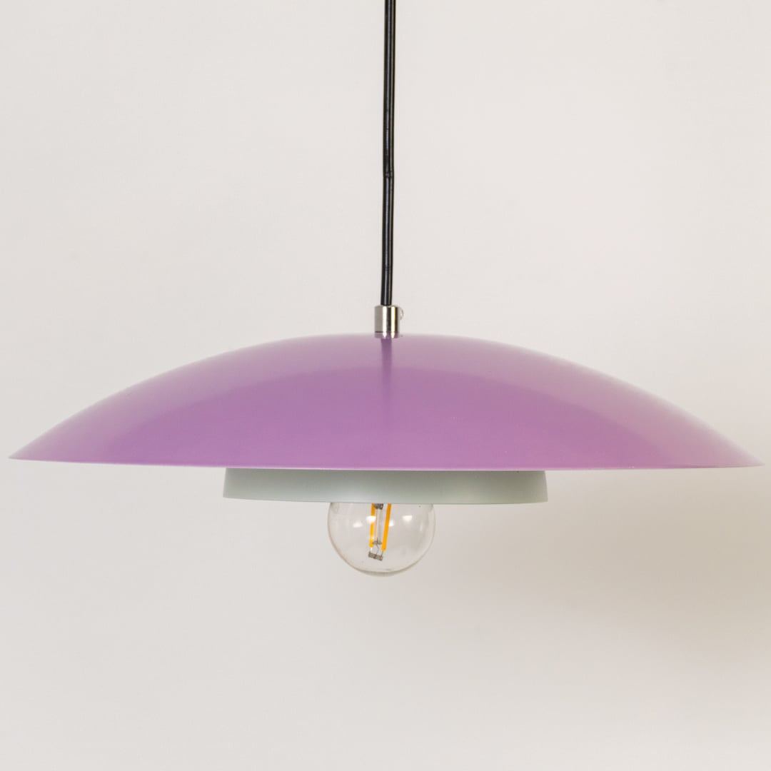 Closeup of lavender metal pendant light showing smooth dome and white inner plate for modern interior home decor.