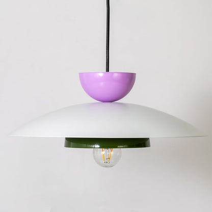 Closeup of multicolor metal pendant light showing white dome green ring and purple top for modern home interior decor.